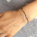 Wrist wearing black silk bracelet with silver wire