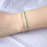 Wrist wearing black silk bracelet with gold wire