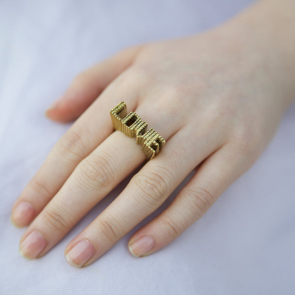 Hand wearing brass 3d love ring